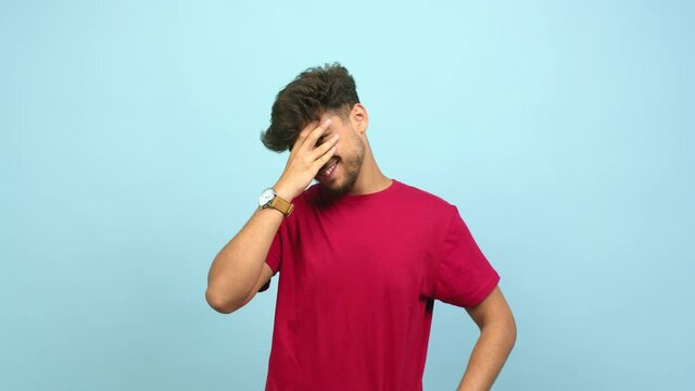 Young arab man embarrassed but laughing, is afraid to face something but is positive