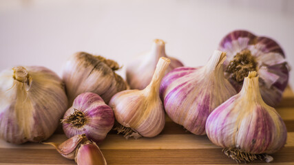 Beautiful, fresh and young garlic is plucked from the garden and lies on a wooden plank.