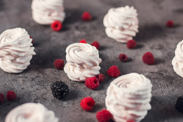 Homemade russian zephyr made of apples, raspberry and blackberry on the dark grey concrete background. Free copy space. White marshmallow