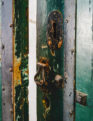 old green, shabby door with rusty iron knock and hole for key