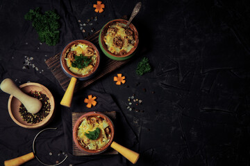  Cocottes with julienne on a black background, top view, free space for the text