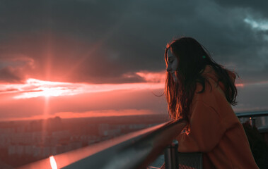 
The girl looks at the sunset