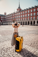 Obraz premium Tourist woman with face mask and luggage in Spain worried about travel restrictions and quarantine