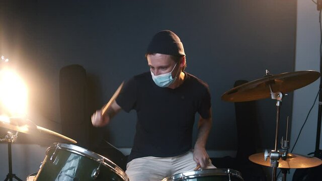 Music studio room. Man playing drums. Life of musicians during the coronavirus. The caucasian male person keeping a distance during the COVID-19 times. 