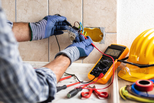 Electrician at work with safety equipment on a residential electrical system. Electricity.
