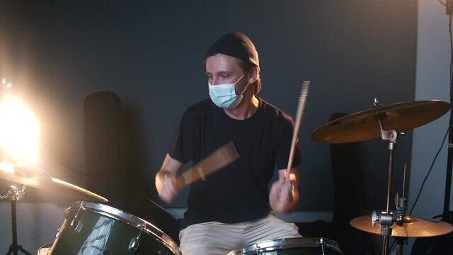 Music studio room. Man playing drums. Life of musicians during the coronavirus. The caucasian male person keeping a distance during the COVID-19 times. 