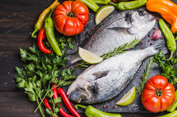 Fresh fish with vegetables, healthy cooking, dorado fish copy space dark background.	