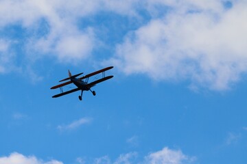 Fototapeta na wymiar alter Doppeldecker fliegt vor blauem Himmel