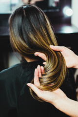 Fototapeta premium Hair stylist showing finished work on hair