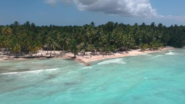 Drone shot approaching the beach from the sea, shot in Saona Island (Dominican Republic) In a sunny day hitting the blue waters of the caribbean
