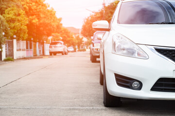 White car parked in line on the road, outdoor parking