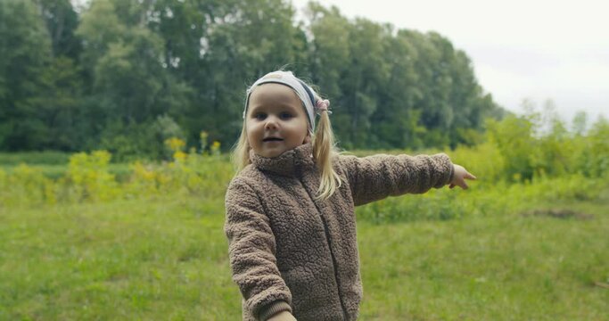 Dziewczynka radosna i uśmiechnięta pokazuje na coś