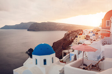 Santorini island Oia sunset landscape. Traditional white houses and church architecture with sea view. Travel to Greece.