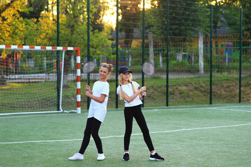 Two girls after lessons go in for tennis on the playground.