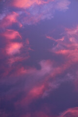 The sun illuminates the sky in such a way that it turns pink and orange. Beautiful summer sunset blue sky with pink clouds.