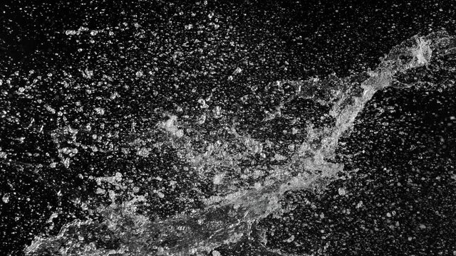 Super slow motion of flying water splashes in collision, black background. Filmed on high speed cinema camera, 1000fps.