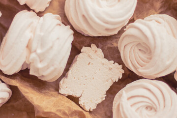 Homemade russian zephyr made of apples, raspberry and blackberry on white concrete background isolated. Free copy space. White marshmallow on the brown beige paper