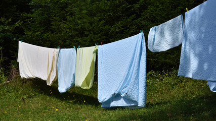 W&auml;sche in hellblau, gelb und lachsfarben h&auml;ngt zum Trocknen auf der W&auml;scheleine, Bettw&auml;sche, Kissenbezug und Deckenbezug auf der Trockenleine