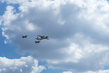 Daylight. large aircraft accompanied by combat vehicles. blue sky