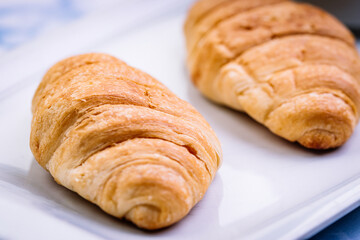 Close-up of breakfast consisting of croissants with white crockery.
