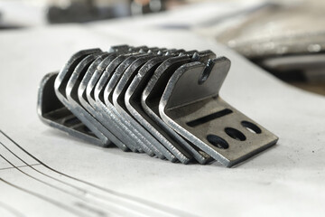 Metal products bent on a bending machine lie on a white background. Factory made products.