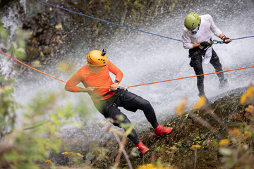 Two Amateur Man rappelling down a waterfall - obrazy, fototapety, plakaty