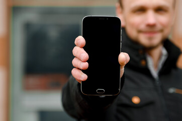 Handsome businessman freelancer smiles and holding a mobile phone