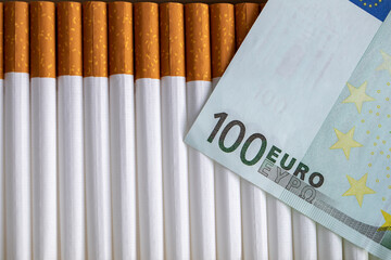 One hundred euro bill and cigarette tubes.
