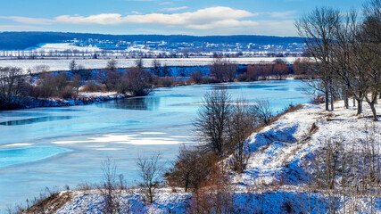 Winter landscape with river and trees on the rocks