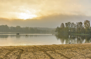 Foggy morning on the beach located on the shore  lake.