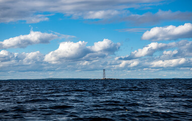 landscape with islands passing ships on the background of blue water and blue sky from the side of a high-speed boat