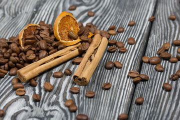 Coffee beans and spices. On a surface of brushed pine boards painted black and white.