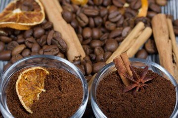 Coffee beans. Ground coffee in containers and spices. On a surface of brushed pine boards painted black and white.