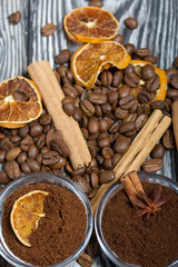 Coffee beans. Ground coffee in containers and spices. On a surface of brushed pine boards painted black and white.