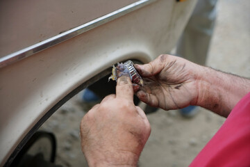 worker putting lubricant lithium grease (NLGI 3) into wheel bearing for ten wheel truck car by hand...