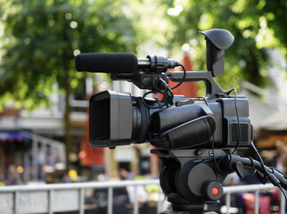 professional video camera and shoots a story for the news column. Camcorder on tripod. High...