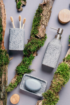 Bamboo bath accessories - soap dispenser, dish, tooth brush, organic dry shampoo for personal hygiene on green moss texture. Copy space. Top view. Zero waste, plastic free, sustainable concept