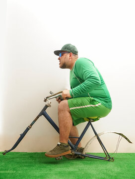  Man Riding bicycle without wheels on white Wall Background. Set as Copy Space for Text. Vintage Style. Bike in crash,Waiting for repair, parked next to a concrete wall.