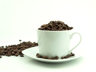 Roasted coffee beans in a white cup on a white plate as a background