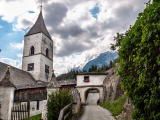 Fototapeta na wymiar Die malerische Ortschaft Pürgg auch Kripperl der Steiermark bezeichnet, mit Kirche und Torbogen bei bewölktem Himmel
