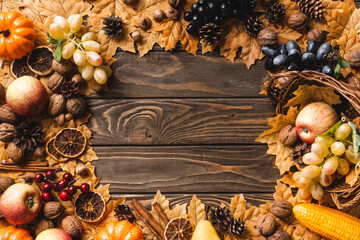 top view of round frame made of autumnal harvest and foliage on brown wooden background