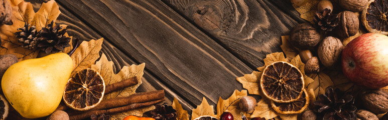 top view of autumnal harvest and foliage on brown wooden background, panoramic shot