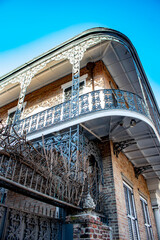 Looking up at a Large Elaborate Wrought Iron Balcony on a Brick Town Home in the French Quarter of New Orleans, Louisiana, USA