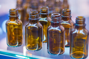 Close up view - medical empty glass brown bottles in showcase at pharmaceutical exhibition, pharmacy laboratory. Pharma industry, science, medicine, experiment and healthcare concept