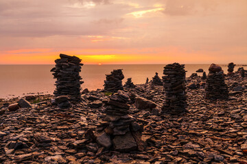 Beautiful stone pyramid built from pieces of rocky shore of Baltic sea. Sunset time.