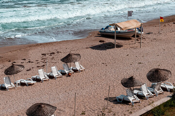  sunbeds and umbrellas on the beach  with clear sea. holiday, tourism and summer theme