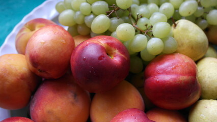 Nectarines, pears, peaches, green grapes close-up.