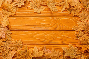 top view of autumnal foliage arranged in frame on wooden background