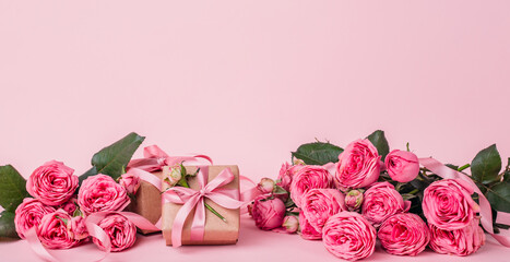 banner with copy space and soft pink background. roses and kraft gift boxes.