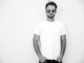 Portrait of handsome confident stylish hipster lambersexual model.Man dressed in white T-shirt....